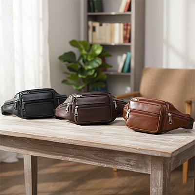Sacoche banane homme​ en trois couleur sur petite table à café en bois