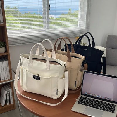 Trois pochettes ordinateur pour femme blanches beige et noires posées sur une table près d’un ordinateur portable dans un intérieur lumineux.