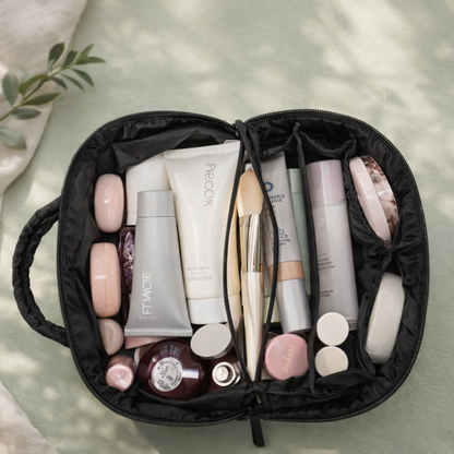 Trousse à maquillage élégante noire ouverte avec produits de beauté organisés, vue de dessus sur fond linge en lin
