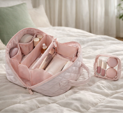 Trousse à maquillage élégante rose ouverte avec compartiments et pochette assortie, posée sur lit blanc