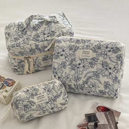 trousse de maquillage matelassée élégante fleurie avec grande moyenne et petite capacité sur fond blanc