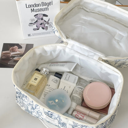 trousse de maquillage ouverte matelassée élégante fleurie avec grande capacité sur bureau blanc