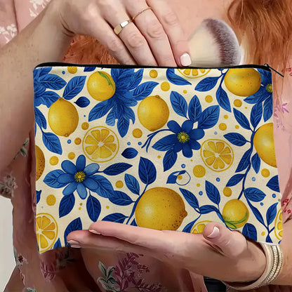 trousse de maquillage fantaisie motif citrons jaunes et feuilles bleues tenue à la main par une femme