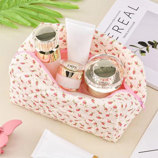 Trousse de maquillage rose en coton matelassé, ouverte, exposant divers flacons de produits, démontrant sa grande capacité.