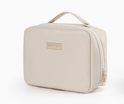 Trousse de toilette femme beige au design sobre et raffiné avec poignée et fermeture zippée, présentée sur fond blanc pour un usage quotidien ou en voyage.