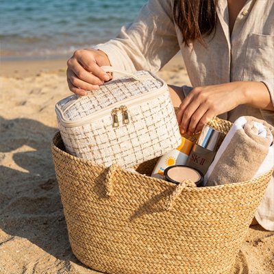 Trousse de toilette femme élégante en tissu, rangée dans un panier de plage