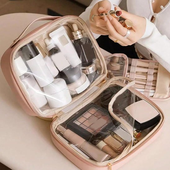 Trousse de toilette femme rose poudré beige clair ouverte, cosmétiques visibles dans les 2 poches