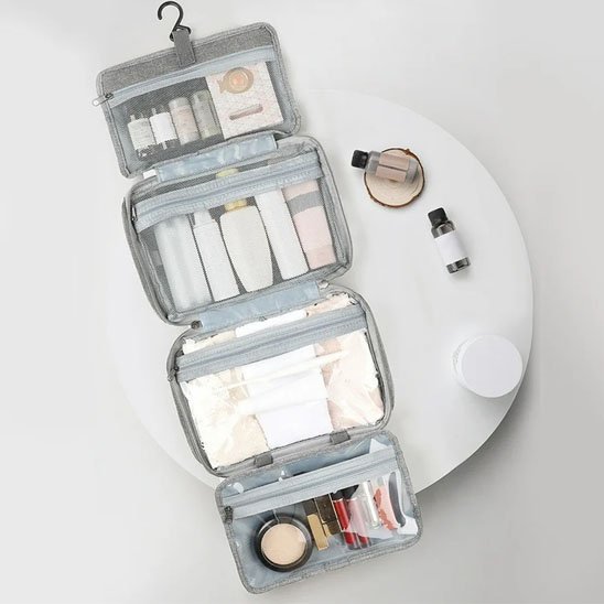 Trousse de toilette femme sur petite table rotative en marbre pour démontrer sa capacité de rangement