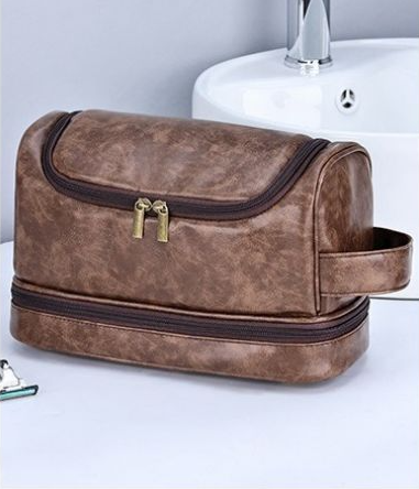 rousse de toilette homme brun cognac style cuir posée sur un lavabo, double compartiment zippé, design élégant et pratique pour le voyage.