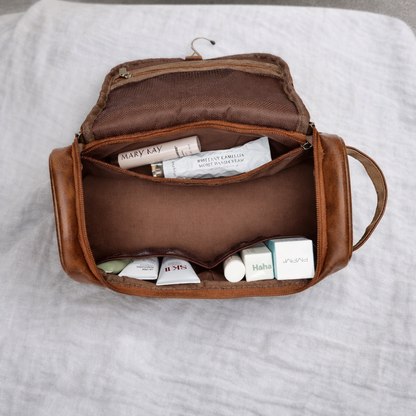 Trousse de toilette homme vue intérieure, compartiments bien organisés contenant cosmétiques et accessoires, rangement optimisé et facile d’accès.