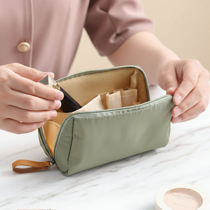 Petite trousse de toilette verte ouverte sur comptoir avec tous les essentiel pour une journée au boulot