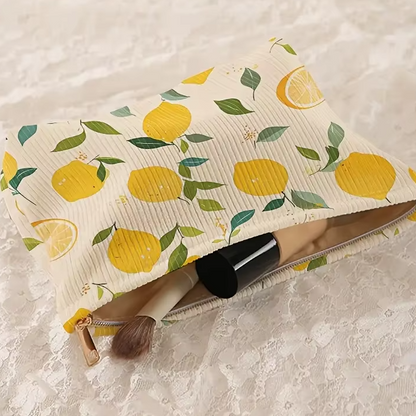 trousse maquillage à citrons posée sur dentelle, avec pinceau et produit cylindrique