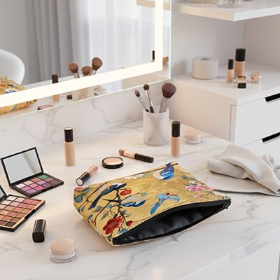Trousse maquillage au motifs d'oiseaux, ouverte sur coiffeuse, avec fermeture éclair robuste, élégante et pratique pour organiser vos produits