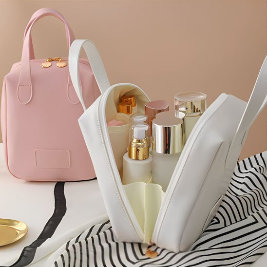 trousse maquillage blanche ouverte sur le devant et le modèle rose à l'arrière fermé dans un décor épuré