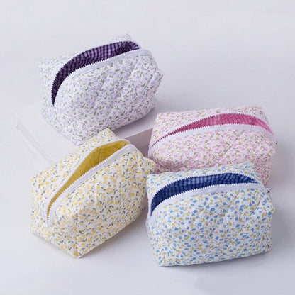 trousse maquillage fleurie matelassée en tissu posée au sol décor zen bois clair mur beige lumière douce quatre modèles