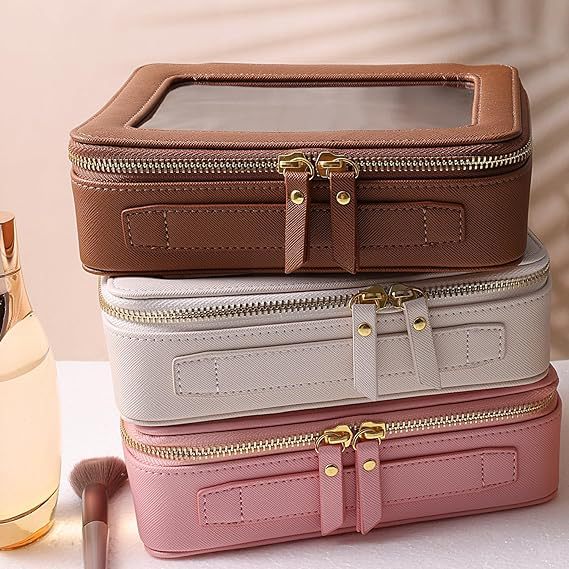 Trousse maquillage marron, blanc et rose empilées avec design structuré et fermetures dorées, idéales pour comparer tailles et couleurs du modèle