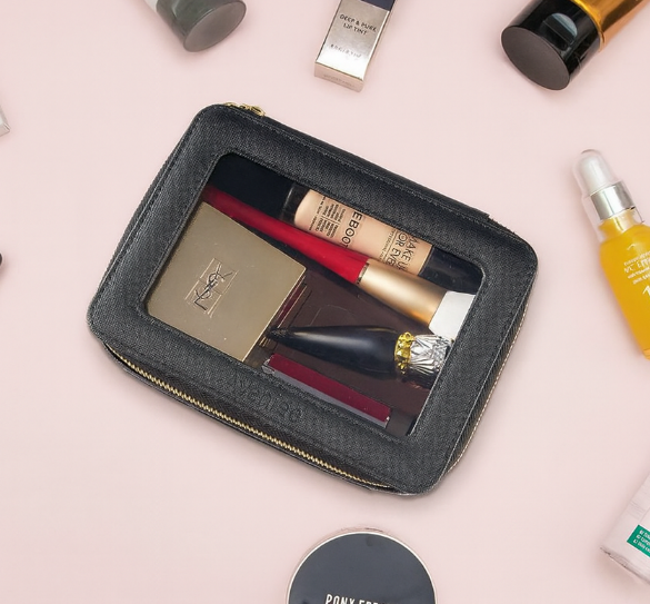 Trousse maquillage noire élégante avec fenêtre transparente, fermeture zippée dorée, idéale pour organiser les produits beauté à la maison ou en voyage