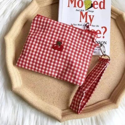 Trousse maquillage à carreau sur un plateau beige 