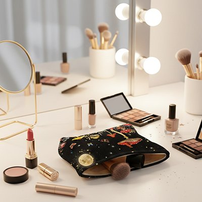 Trousse maquillage sur comptoir de salle de bain de marbre blanc et un magnifique miroir illuminé avec tout le maquillage nécessaire