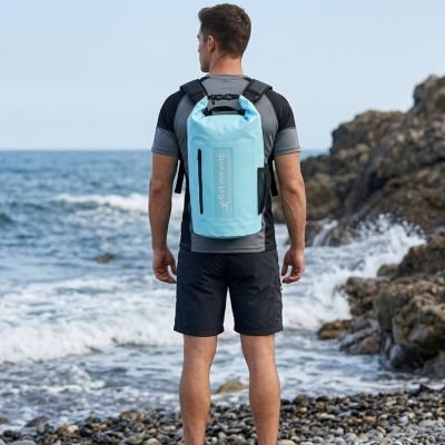 Un homme regarde la mer avec Sac à dos étanche bleu