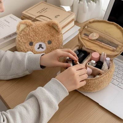 Une trousse à maquillage beige en forme d’ours est ouverte et remplie de produits cosmétiques. Une personne range son maquillage 