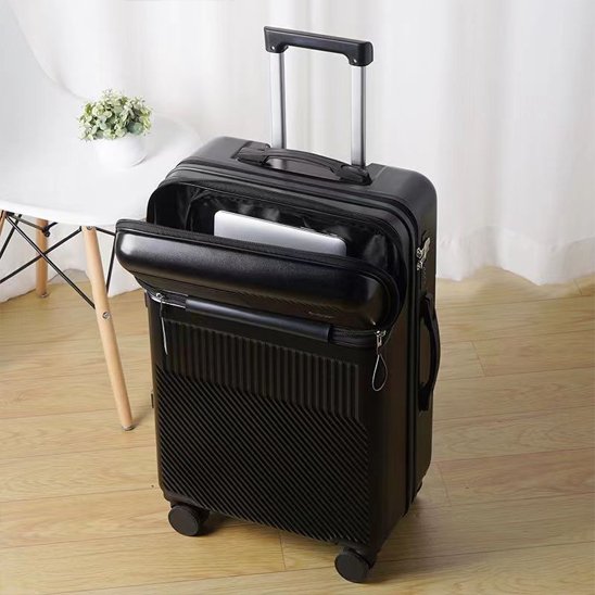 Valise rigide 24 pouces noire dans un salon, compartiment frontal ouvert avec PC